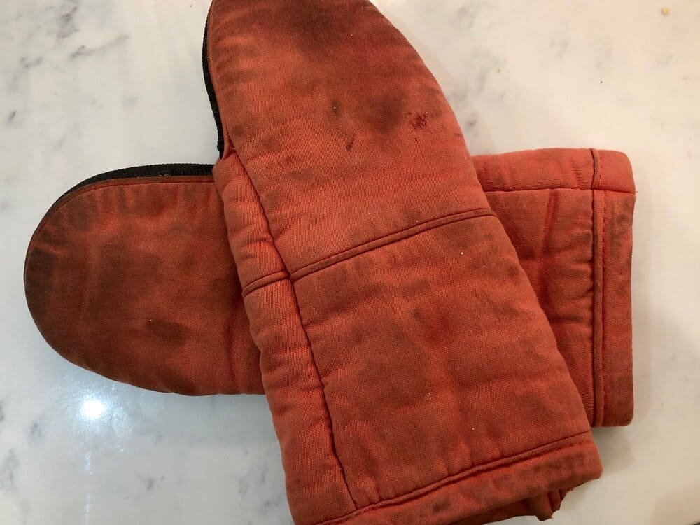Oven mitts laid out on a countertop