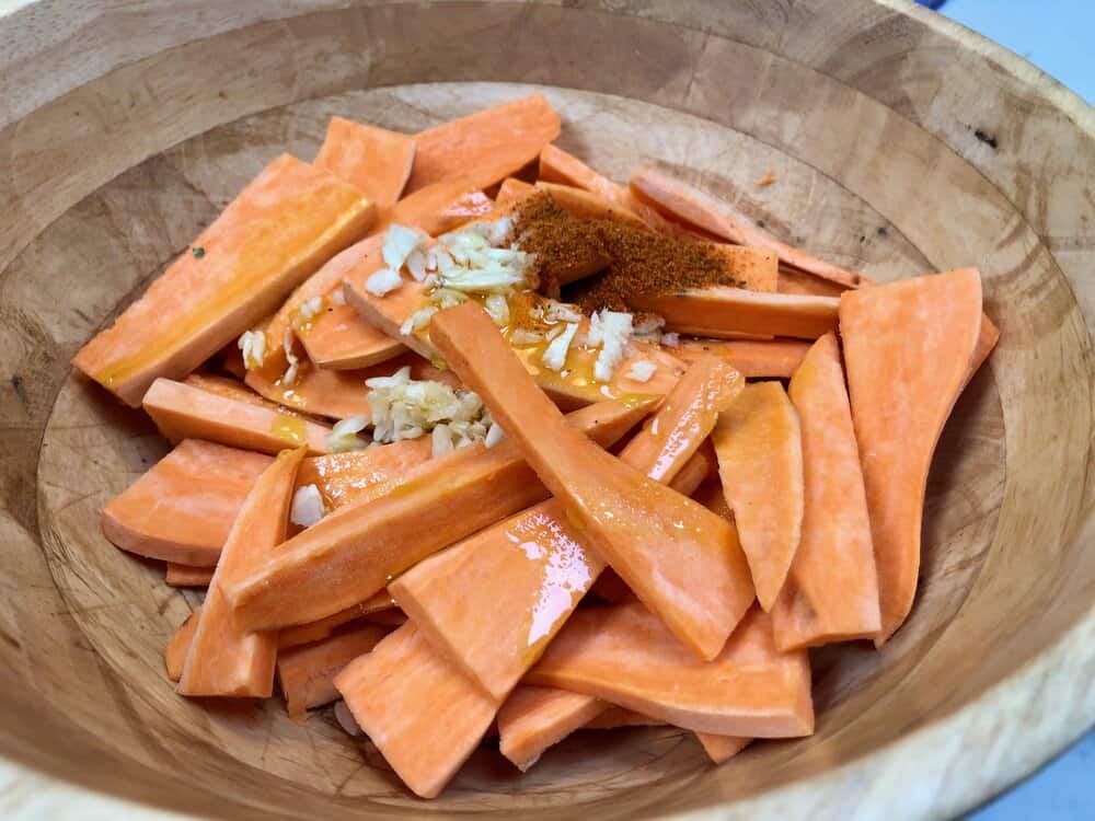 Sweet potatoes marinating in a bowl