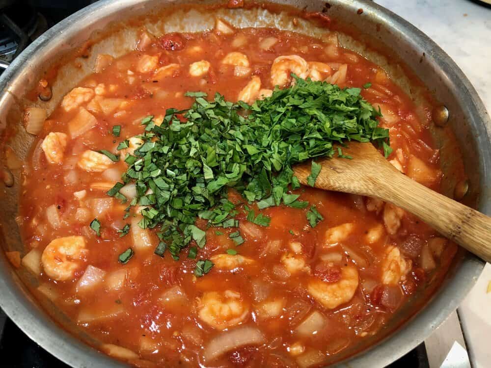 Shrimp and tomato sauce in a pan sprinkled with parsley