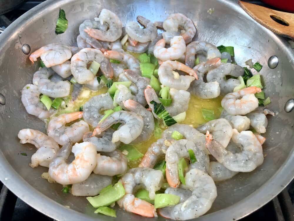 Shrimp cooking in a pan with bok choy