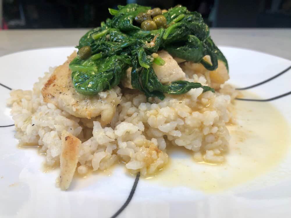 Chicken and spinach over rice on a plate