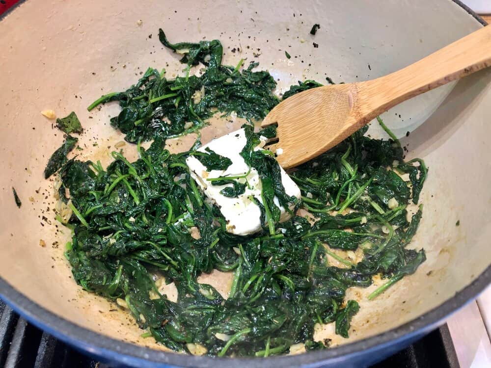 Spinach and cream cheese cooking in a pot