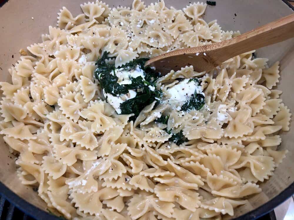 Farfalle, spinach and cream cheese cooking in a pot