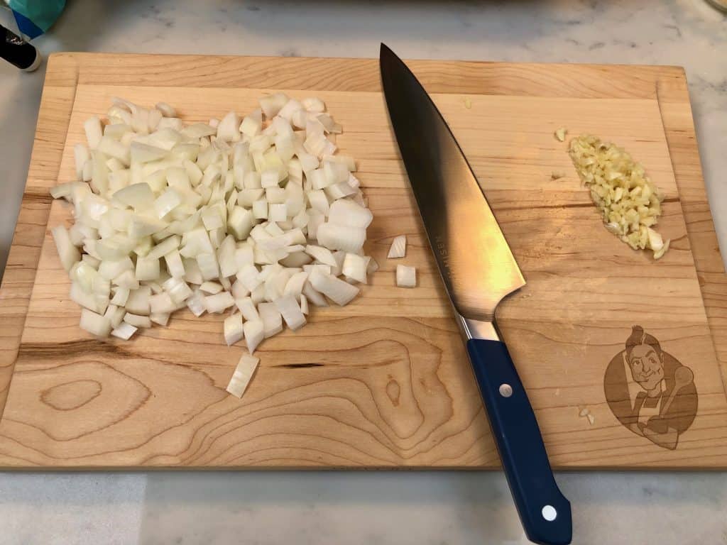 Chopped onion and garlic on a cutting board