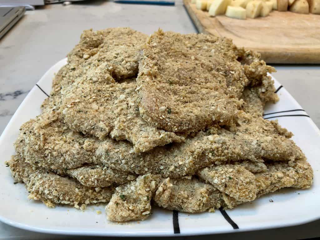 Breaded chicken cutlets stacked on a plate