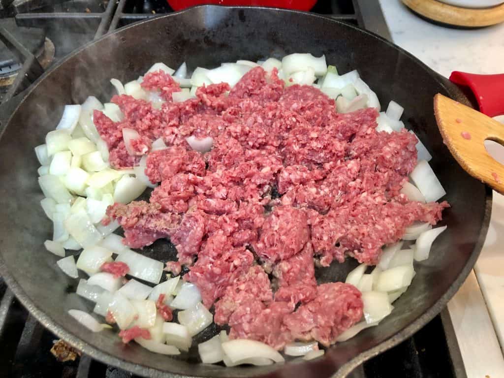 Ground beef and onions in a skillet