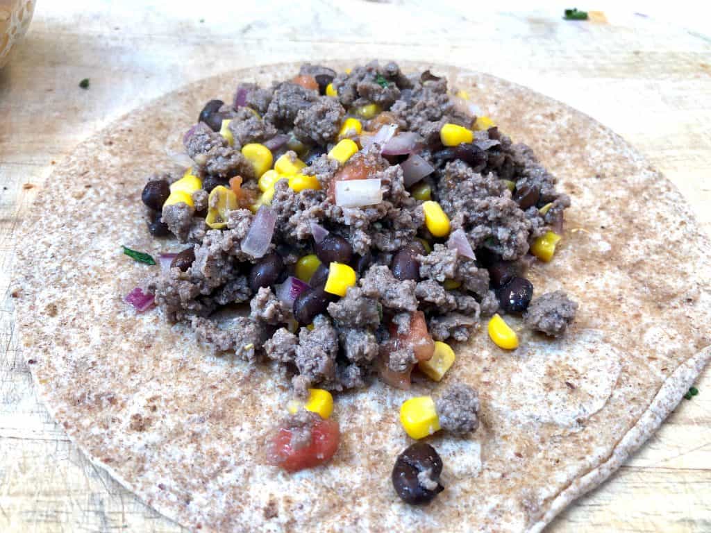 Ground beef mixture sitting on a tortilla