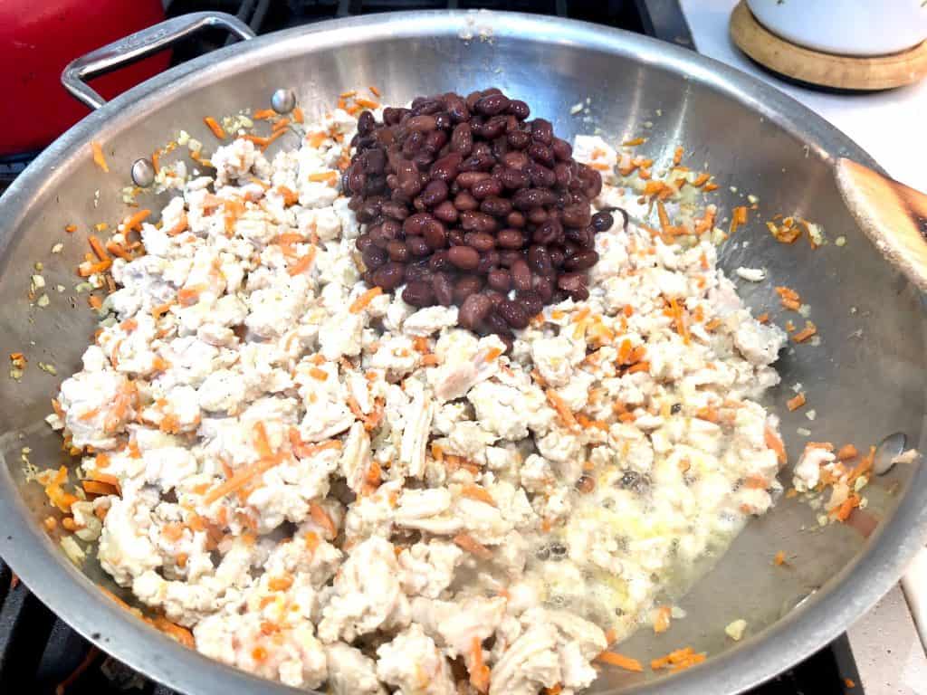 Black beans added to cooked turkey meat with vegetables
