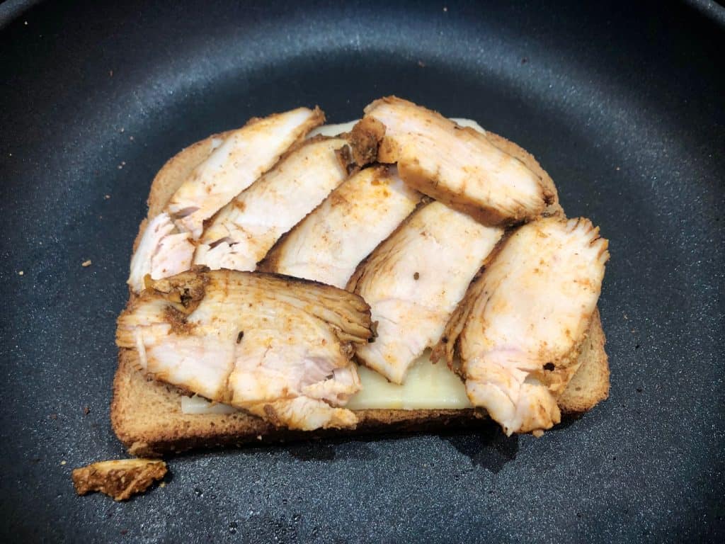 Sliced chicken on bread in a pan