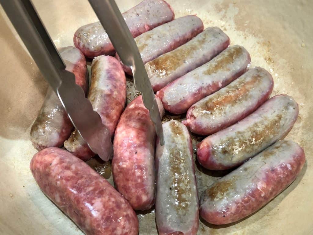 Sausage browning in a pan