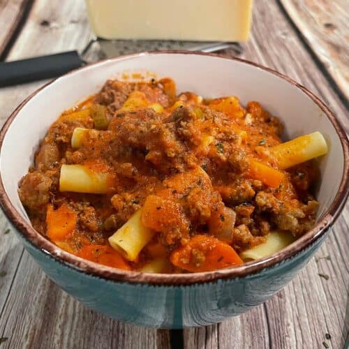 Creamy bolognese with rigatoni and vegetables in a bowl.