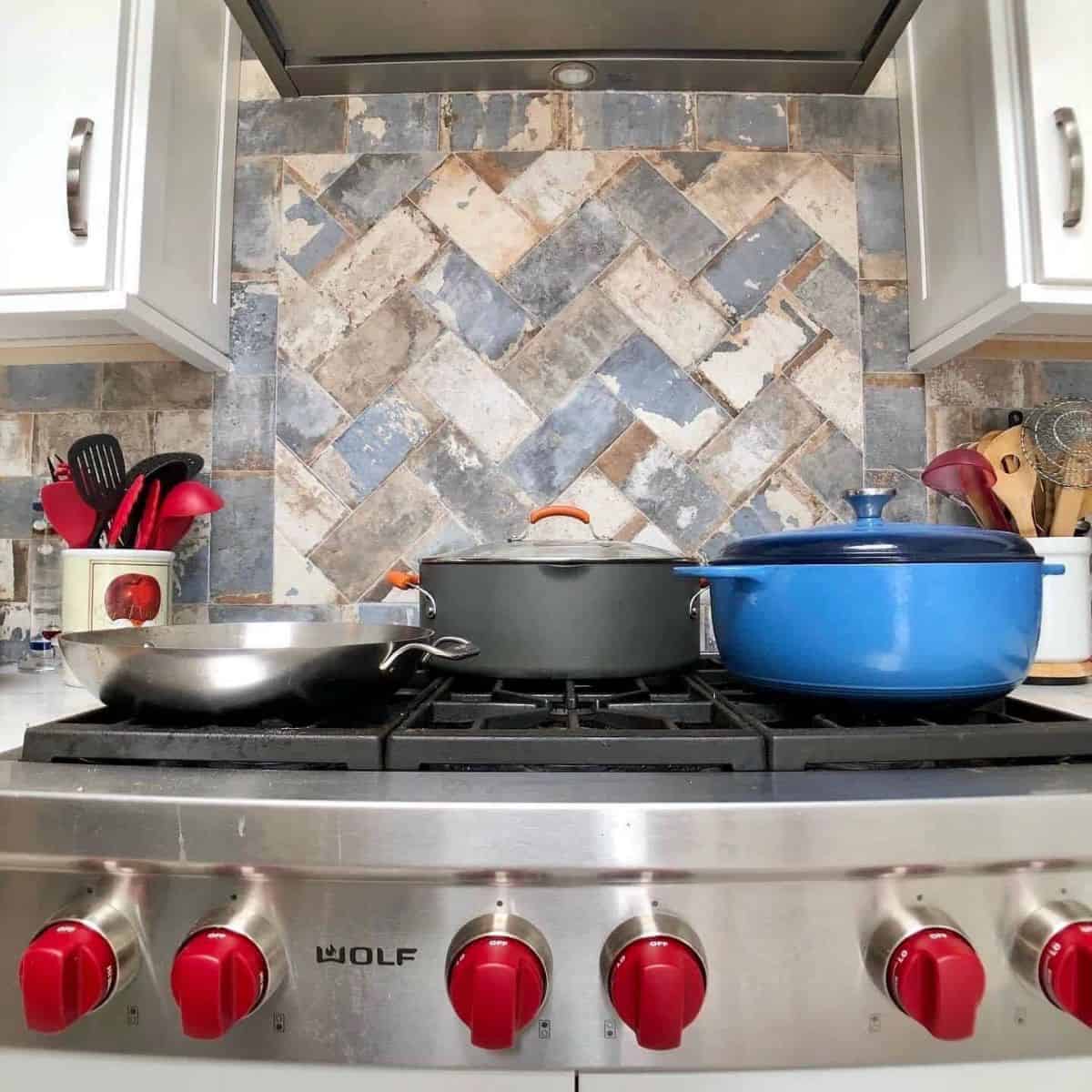 a picture of a wolf rangetop with 3 pots resting on top of the cooktop.